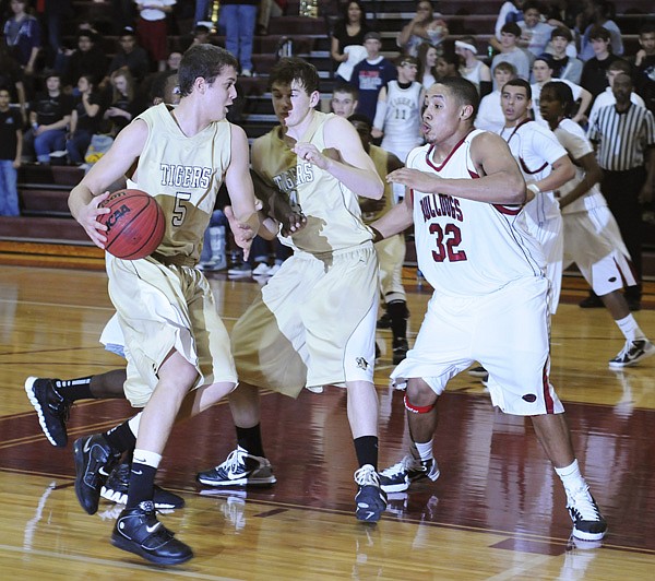 Bentonville’s Nick Smith, left, drives the ball to the hoop as Springdale High’s Kempys Robinson defends in the second half of the game Tuesday in Springdale.