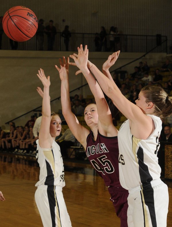 Lincoln junior RaShelle Goldman, center, shoots as Charleston sophomore Paityn McLaughlin, right, defends during the first half Wednesday of the Class 3A Region 1 Tournament in the Tiger Center in Charleston.