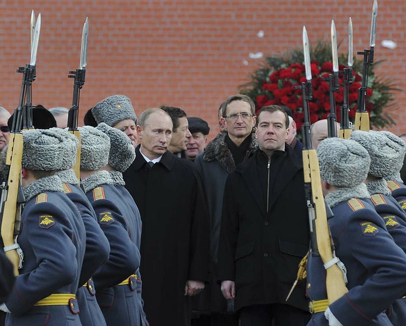  Russian Prime Minister Vladimir Putin (left) and President Dmitry Medvedev attend a wreath-laying ceremony Wednesday at the Tomb of the Unknown Soldier in Moscow. 