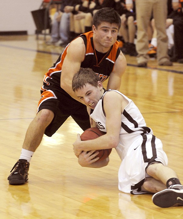Pea Ridge's Dakota Woodward, below, and Gravette's Darrick Strzelecki struggle for the ball Wednesday, Feb. 16, during the 4A-1 Conference Tournament at Pea Ridge. 
