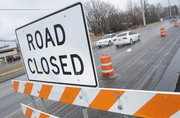 Traffic moves through the construction area Thursday on Southwest 14th Street in Bentonville. Construction is expected to be complete by the end of April.