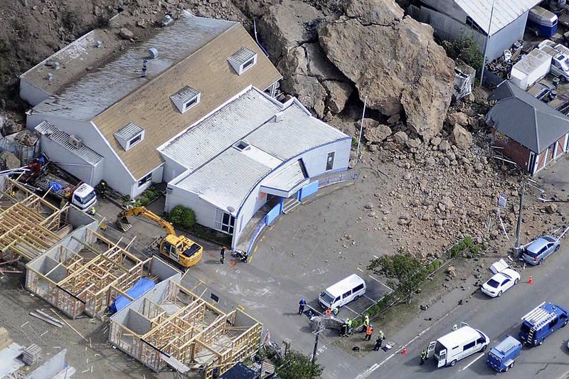 Huge boulders rest where they landed between buildings in Christchurch suburb of Sumner, New Zealand on Thursday, after the city was hit by a 6.3 magnitude earthquake Tuesday.  