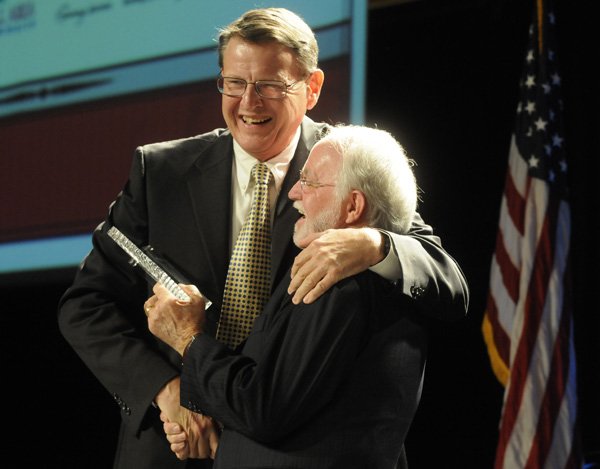 David Thrasher, left, hugs Dick Trammel after Thrasher received the Dick Trammel Good Neighbor Award on Friday at the Rogers-Lowell Area Chamber of Commerce banquet at the John Q. Hammons Center in Rogers.