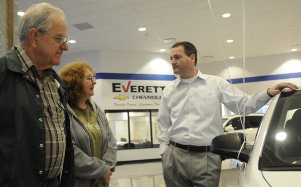 Jimmy Young, from right, general manager of the Everett Cheverolet, talks with Teresa Abshier and her husband, Ron Abshier, as they shop for a car Thursday at the dealership in Springdale. The dealership was recently sold from Fletcher Chevrolet to become Everett Chevrolet.