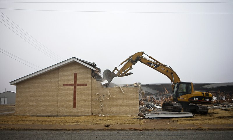 A track hoe demolishes the First Baptist Church of Picher, Okla., in late January as the toxic town shrinks into rubble.

 