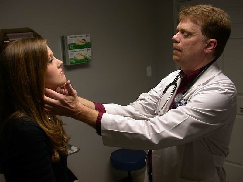 Dr. John House examines Stacey Quayle at the Bono Barter Clinic in Craighead County, where House accepts goods and services as payment for medical care. 