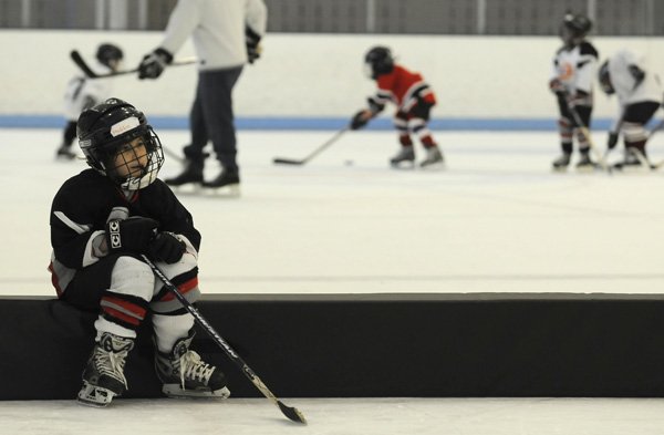 Maddie Harp, 8, takes a break during hockey practice on Feb. 12 in the Jones Center in Springdale.