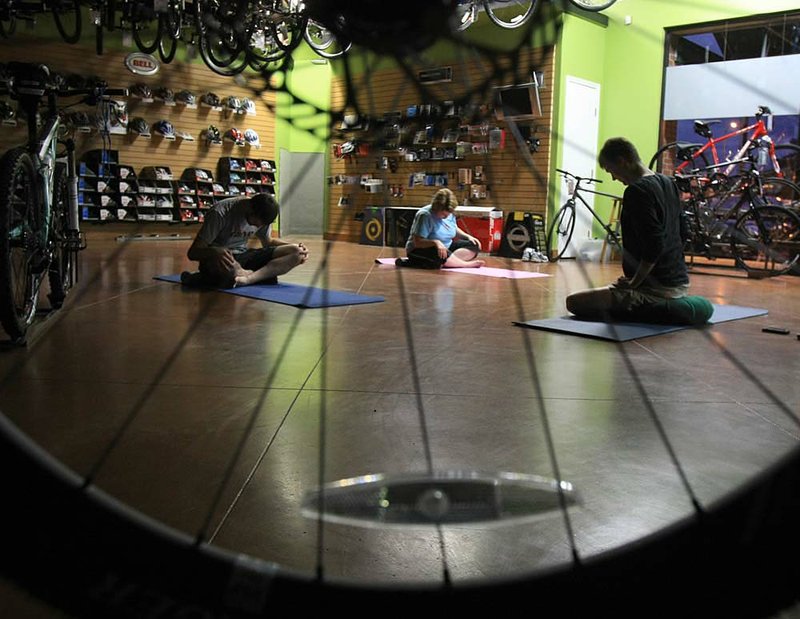 Frank Webber (from left), Kathy Stevens and instructor Nick Pippins warm up during a yoga for bicyclists class at Chainwheel in Little Rock. 