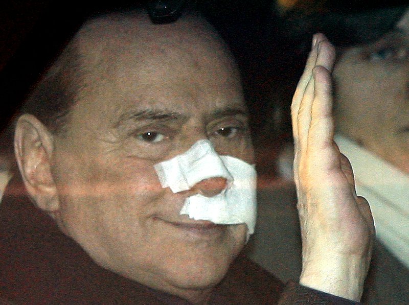 This Dec. 17, 2009 file photo shows Italian Premier Silvio Berlusconi waving from his car as he arrives at his home in Arcore, Italy after being attacked by a mentally ill man at a political rally.