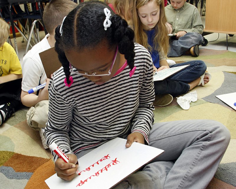 Third-grader Alexia Dillard tries her hand at cursive writing during a penmanship lesson at Conway Elementary School. 