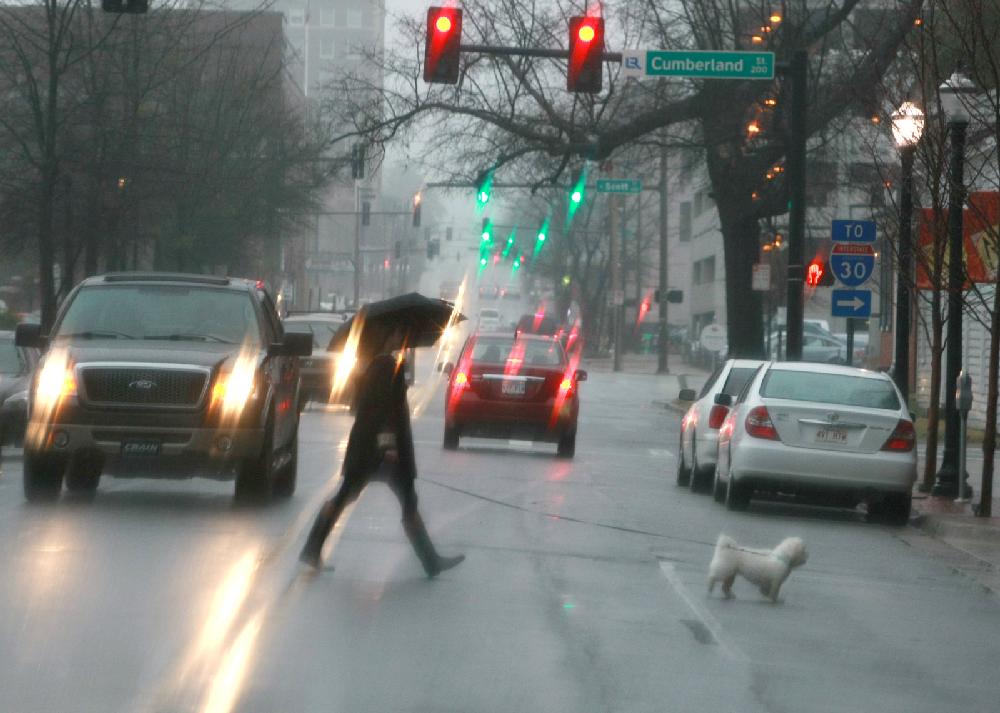 Arkansas Democrat-Gazette/RICK MCFARLAND--03/08/11-- A pedestrian walks their dog across East 3rd Street in a misty rain in Little Rock Tuesday afternoon.