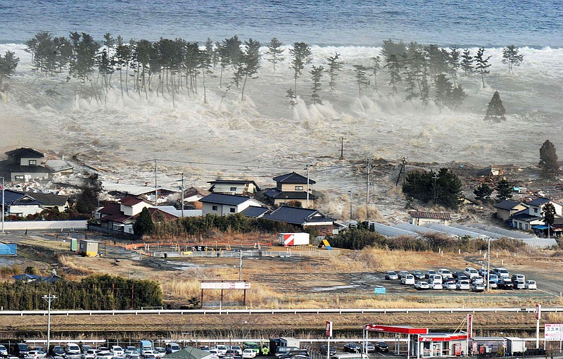 Waves from a tsunami hit residences after a powerful earthquake in Natori, Miyagi prefecture, Japan, on Friday, March 11, 2011. The largest earthquake in Japan's recorded history slammed the eastern coast Friday. 