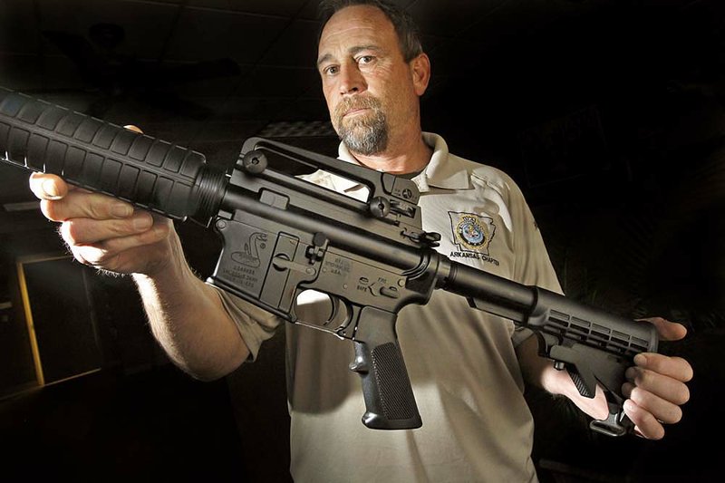 Steve Cruse, owner of Cruse Uniform which supplies equipment to the Little Rock Police Department, shows an M-4 style .223-caliber carbine rifle that patrol officers will begin using. 