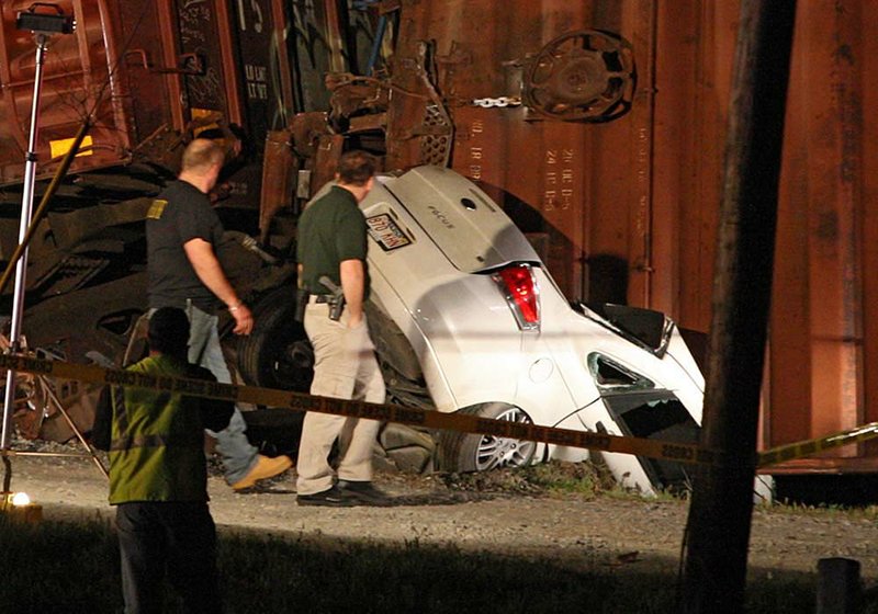 Emergency workers investigate a fatal wreck between a train and car along 145th Street near Wrightsville Sunday evening. 