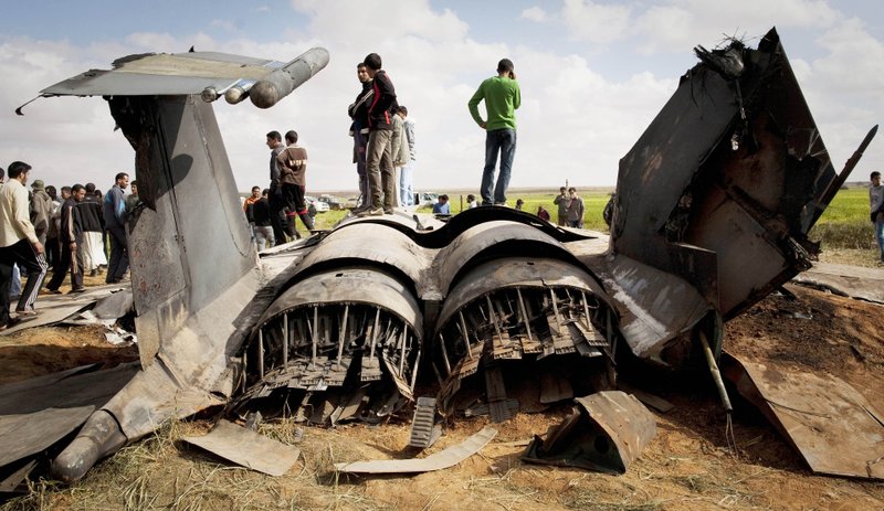 Libyans inspect the wreckage of a US F15 fighter jet after it crashed in an open field in the village of Bu Mariem, east of Benghazi, eastern Libya, on Tuesday, March 22, 2011, with both crew ejecting safely. 