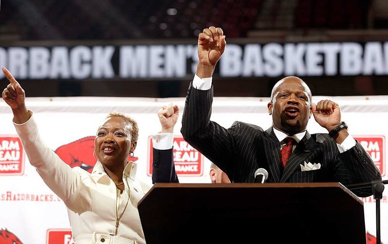 Mike Anderson (right) and his wife, Marcheita, "call the Hogs" during a news conference introducing Anderson as the new men's basketball coach inside Bud Walton Arena at the University of Arkansas in Fayetteville on Saturday.