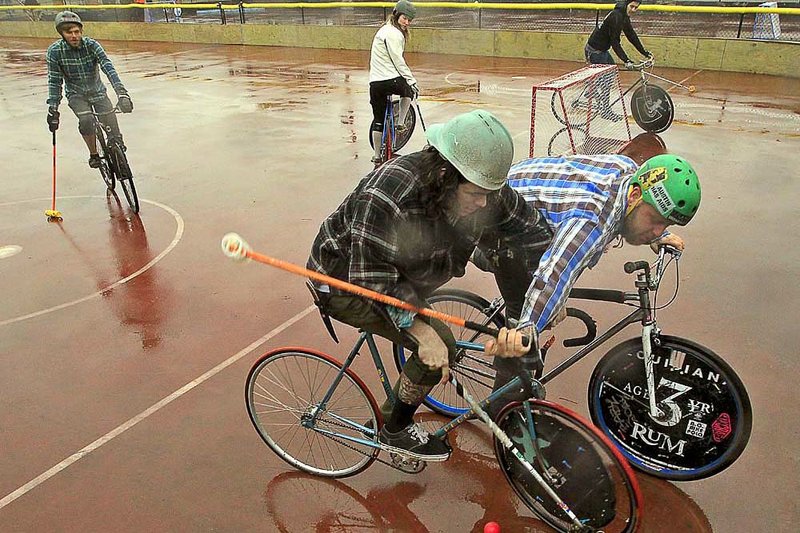 Drew Wilson (center) of the Little Rock Stone Goats team fends off Jeff Gerhart of the Gulf South Boys during the South Central Bike Polo Championships on Saturday in Little Rock. 