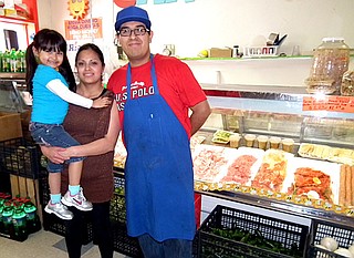 Daniel Ortiz, manager and butcher of the Carniceria Guanajuato Meat Market in Decatur, stood in front of the store’s meat case with his wife Marina and daughter Nelly.