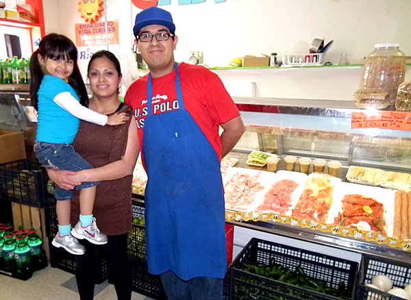 Daniel Ortiz, manager and butcher of the Carniceria Guanajuato Meat Market in Decatur, stood in front of the store’s meat case with his wife Marina and daughter Nelly.