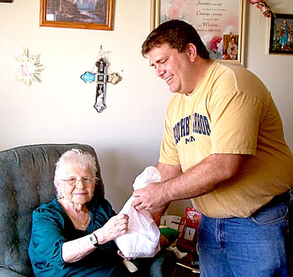 Gravette Mayor Byron Warren participated in the Mayors for Meals Day observed by the Billy V. Hall Senior Activity Center. He is shown delivering one of the meals to Shirley Clark. For information about the program, call the center at 787-5950.