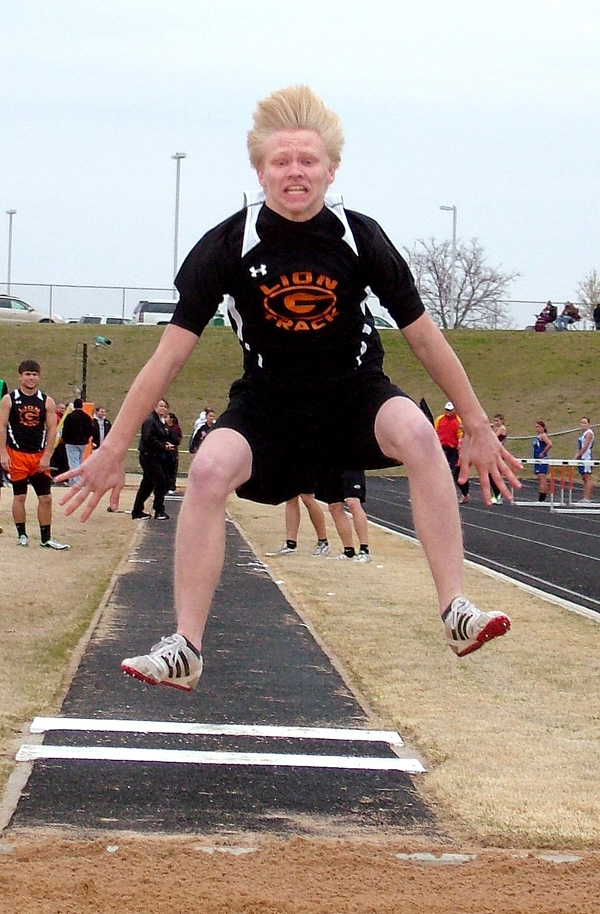 Gravette long jumper Zach Campbell (right) clears some ground during track competion at Gravette on Monday.