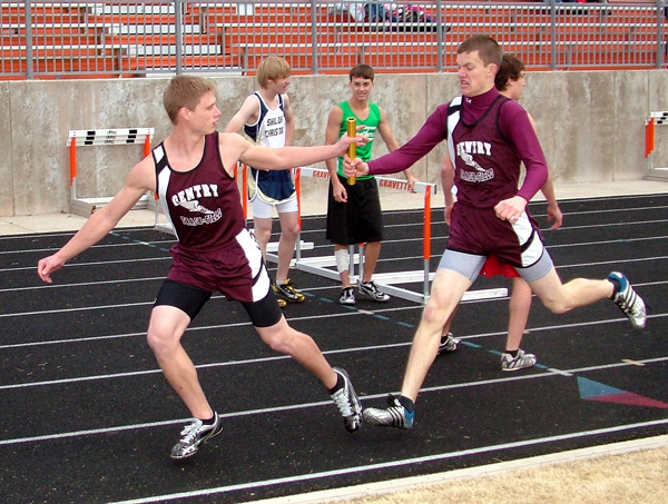 Gentry runner Kevin Parrish passes the baton to Clay Norman in the 4x400 relay at Monday's track meet in Gravette. Gentry boys finished in seventh place with 38 points.