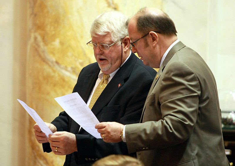 Rep. Bobby Joe Pierce (left), D-Sheridan, and Rep. Barry Hyde, D-North Little Rock, look over copies a proclamation Friday from legislative leaders extending the session to deal with congressional redistricting. 