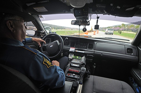 Cpl. Dennis Johnson, of the Arkansas State Police, keeps an eye on traffic Thursday flowing into a work zone on an access road parallel to Interstate 540 near exit 62. Numerous new laws have been approved by legislators in the last few weeks, including changes to which police agencies can patrol interstates and new restrictions on motorists using cellphones in work zones.
