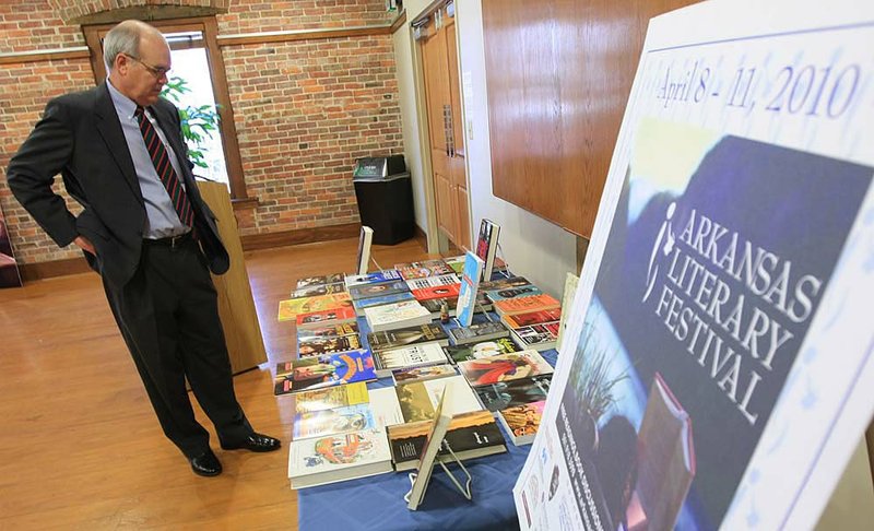 Bobby Roberts, director of the Central Arkansas Library System, reviews a display of books by several participants in the Arkansas Literary Festival during a stop at the Cox Creative Center. 