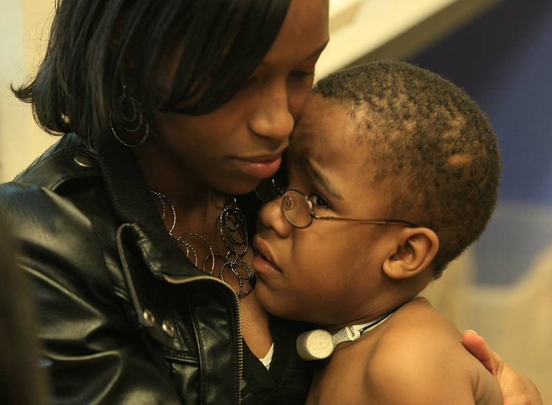 Angela Freeman holds her 3-year-old son, Zavier Bufford, while a nurse takes his blood pressure at a clinic at Arkansas Children’s Hospital. Zavier, who was born premature and has had numerous health problems, sometimes qualifies for Medicaid assistance. 