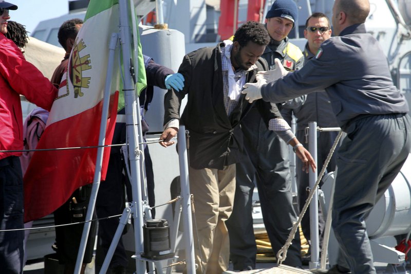 A man is helped out of an Italian Coastguard boat upon his arrival in Lampedusa, southern Italy, Wednesday. Italian coast guard officials were trying Wednesday to rescue migrants lost at sea after their boat capsized off the coast of Lampedusa, a tiny Italian island close to North Africa, officials said. Many were feared dead. The Coast Guard has saved 48 out of 200 believed to be aboard the rickety board, said Pietro Carosia of the Italian Coast Guard. But helicopters also have spotted corpses in the sea, Carosia said, declining to provide a number. The survivors were offered blankets, warm beverages and food as they arrived ashore Wednesday morning. Many suffered hypothermia and some were taken away by ambulance, said Carosia. 