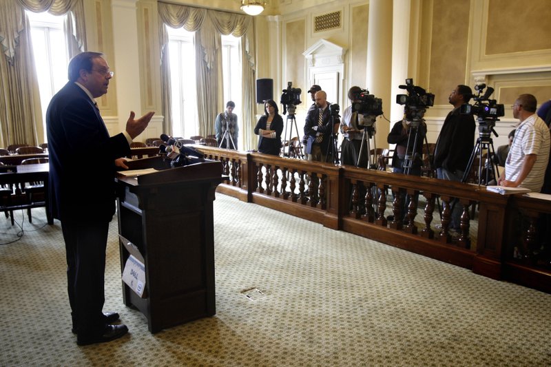 Arkansas Family Council President Jerry Cox, left, speaks to reporters at the Arkansas state Capitol in Little Rock after the state Supreme Court struck down an Arkansas law prohibiting gay couples and other unmarried people who live together from adopting or serving as foster parents.