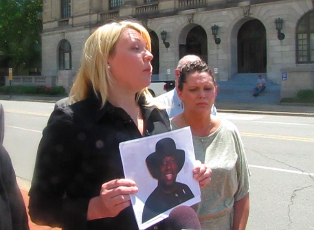 Attorney Jessica D. Arbour, left, holds up a photo of Catholic Priest Charles U. Kanu during a news conference Wednesday outside the Pulaski County courthouse.