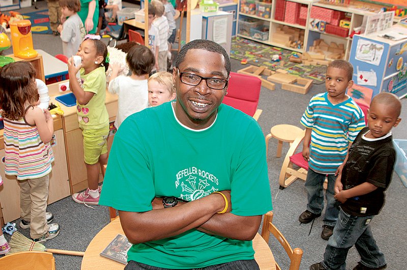 Antonio Moore, who raps under the name Tony Ocean, poses with pupils in his class of 3 year olds at Rockefeller Elementary in Little Rock, where versions of his profanity-free CD are offered in the classroom treasure chest. 