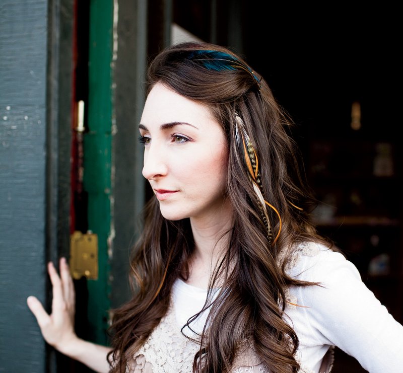 Sarah Sturdivant models a few feather hair extensions. She's become known as the "feather girl" to those seeking these colorful hair extensions. 