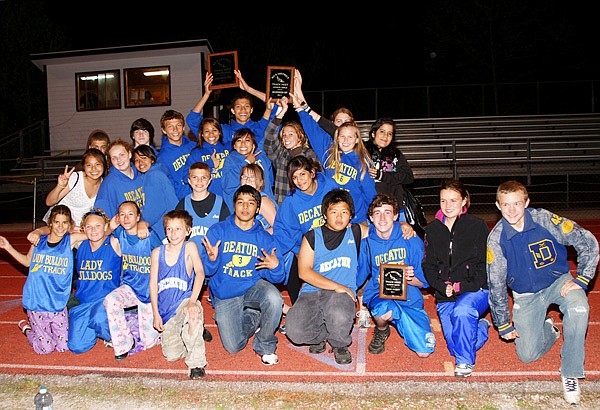The Decatur Junior High track teams posed with their trophies after the boys' team won the conference championship held in Eureka Springs on April 20. The girls' team won second place in the competition, finishing only 10 points behind the champions. Trey Kell, a member of the Decatur boys' team, also took the title of conference most valuable player at the meet.
