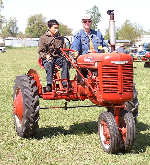 Lane Dannels, 12, takes a drive around the Tired Iron showgrounds on the club's new "driver's ed tractor" with Glenn Smith.