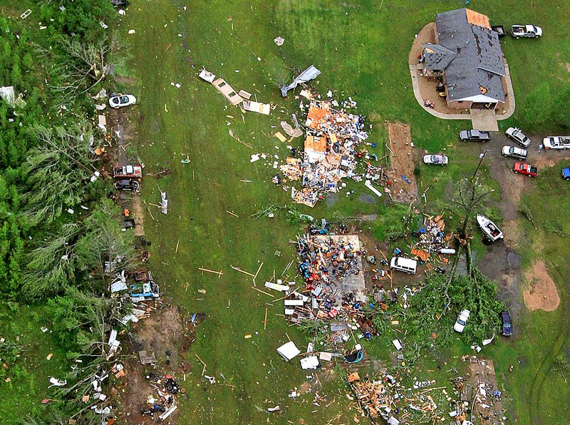 Vehicles, boats and other possessions are scattered among the debris of tornado-obliterated homes Tuesday in Vilonia. 