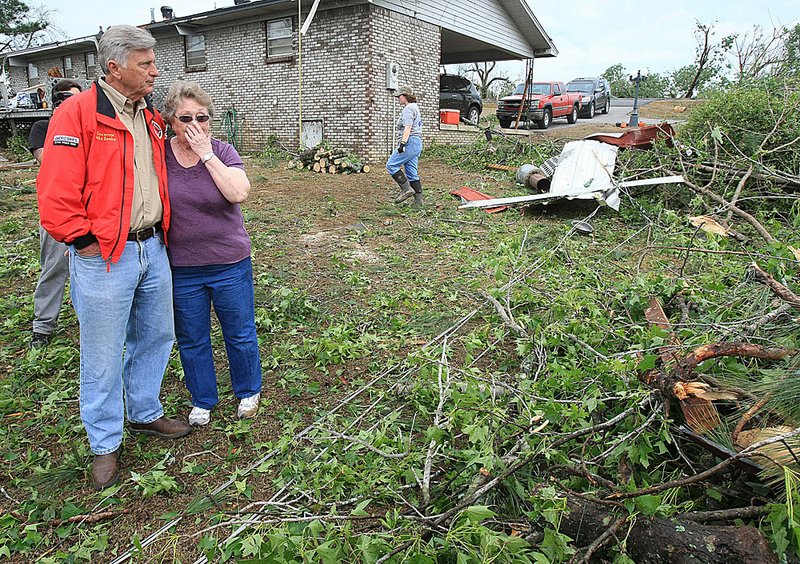 Gov. Mike Beebe (left) comforts homeowner Lou Baker as she looks at her storm-damaged home Tuesday morning in Vilonia. Beebe declared a state of emergency for much of the state. 