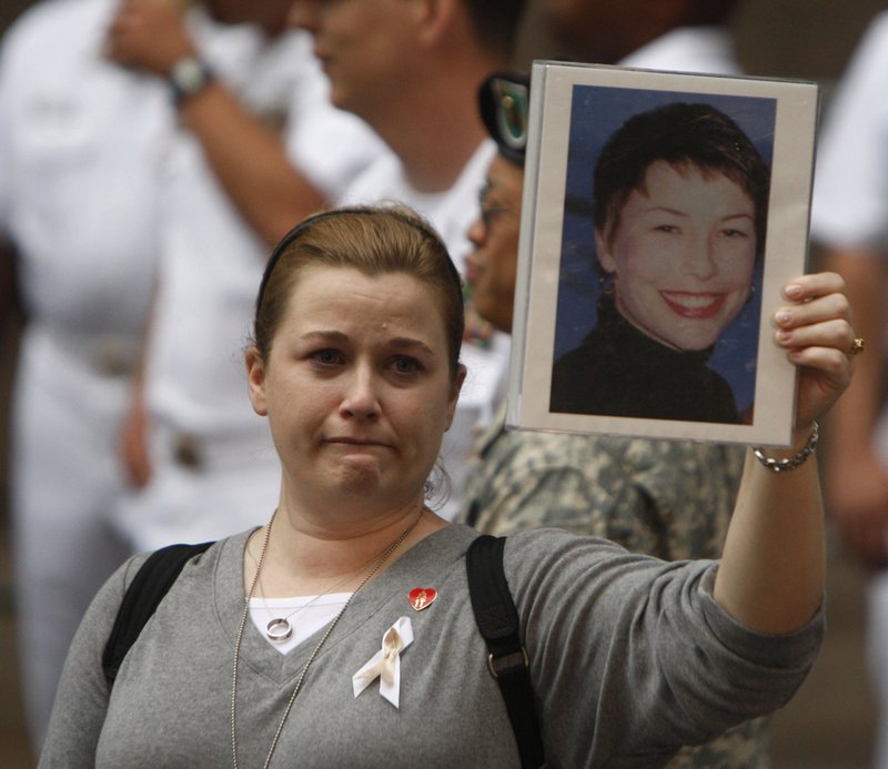 Alyson Low holds a photo of her sister, 9/11 victim Sara Low, an American Airlines flight attendant from Batesville, before a ceremony at New York City's Zuccotti Park, on Tuesday, Sept. 11, 2007. 