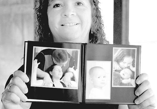 Joy Coonfield shows photos of children and families she helped in childbirthing. 