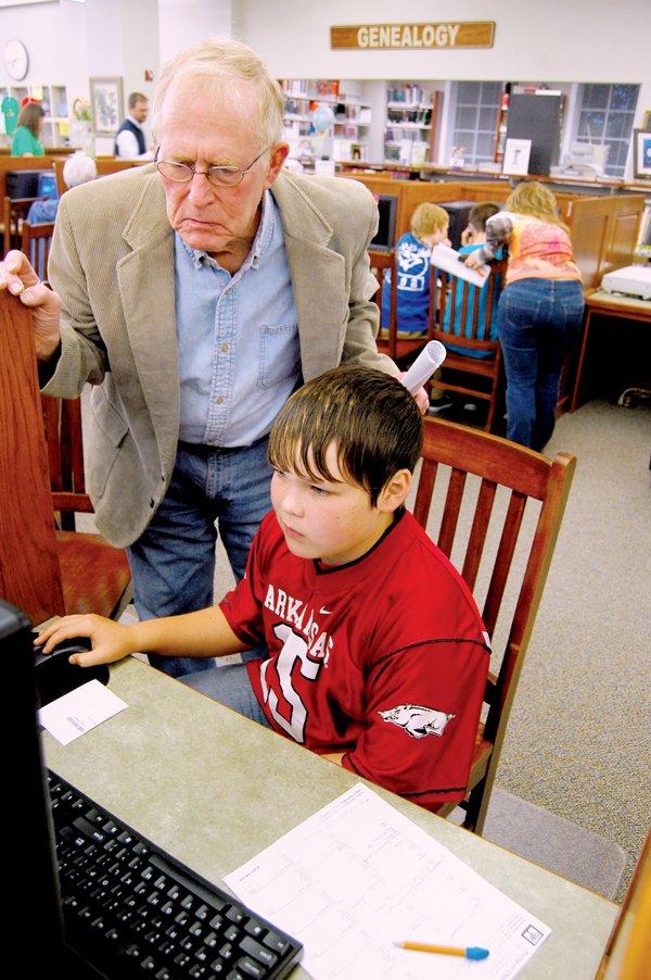 Hot Spring County Historical Society member Dick Welch helps sixth-grader Chance Hansbraugh, 12, with his genealogy research on Monday at the Malvern-Hot Spring County Library. The students met with the historical society to fill in their pedigree charts and learn about genealogy resources.