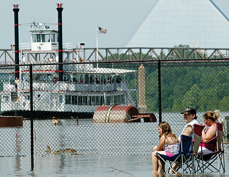 A family cools off Tuesday in the swollen Mississippi River in Memphis. 