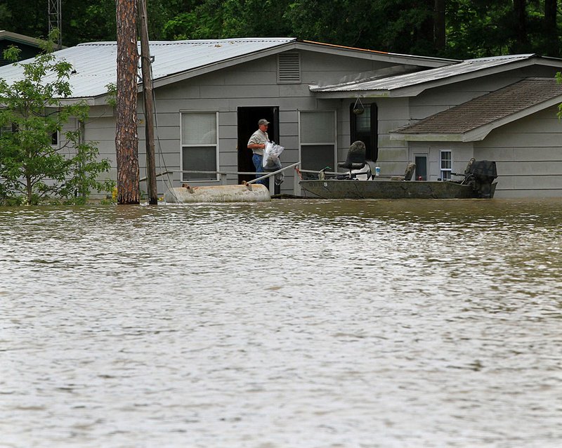 Marshall Ramey collects belongings from his home near Deep Elm as flood waters rise Wednesday afternoon