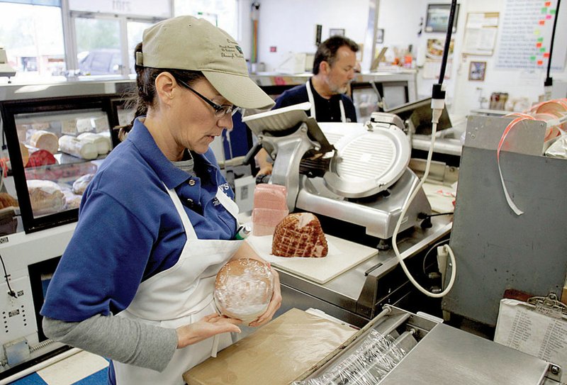 Owners Lorri Lee and David Lee prepare lunch orders last week at Ivan’s Old Time Meat Shop in
Rogers.