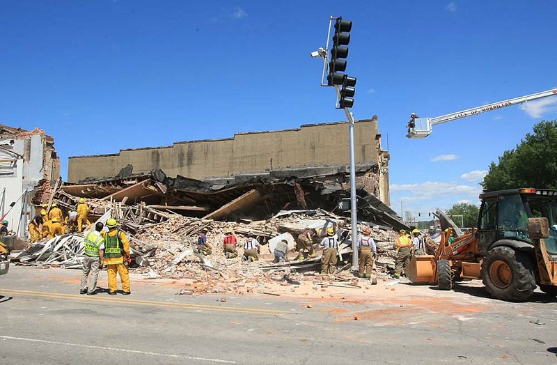 Emergency personnel begin the process of searching through debris from a collapsed building at the corner of Broadway and Division Streets in downtown Morrillton.