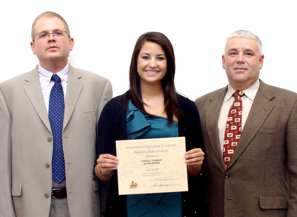 Jacy Alsup was recently awarded two scholarships. Paul Goeringer and Rich McCasland are shown with Jacy as she received the scholarship certificate.
