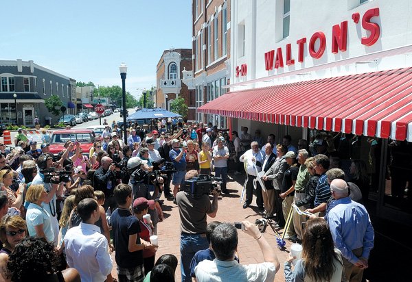 A crowd gathers Saturday as officials cut a ribbon for the newly renovated Walmart Visitor Center on the square in Bentonville. The center features a cafe, museum and working five-and-dime store.