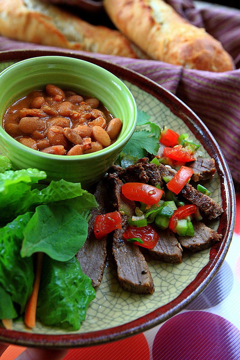 A traditional Santa Maria-style barbecue menu features grilled beef topped with fresh salsa, beans, salad and French bread. 
