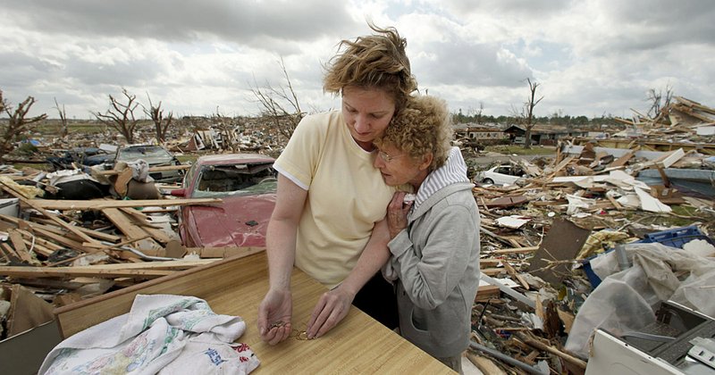 Beverly Winans embraces her daughter Debbie Surlin as they salvage items from Winans’ home in Joplin, Mo. 
